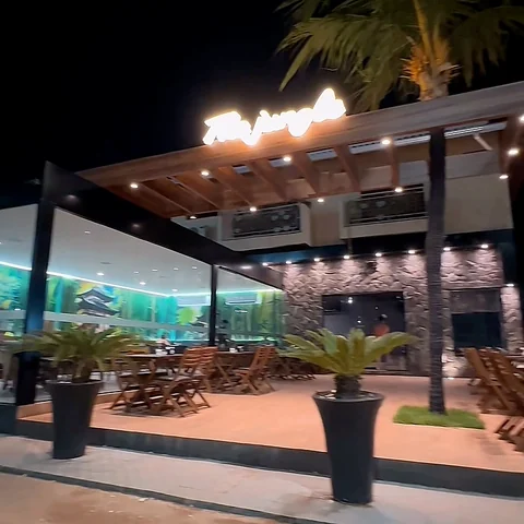 Fachada externa do The Jungle Sushi à noite.