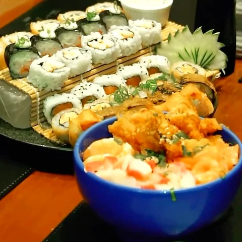 Bandeja de rolinhos de sushi, sem rosto visível.